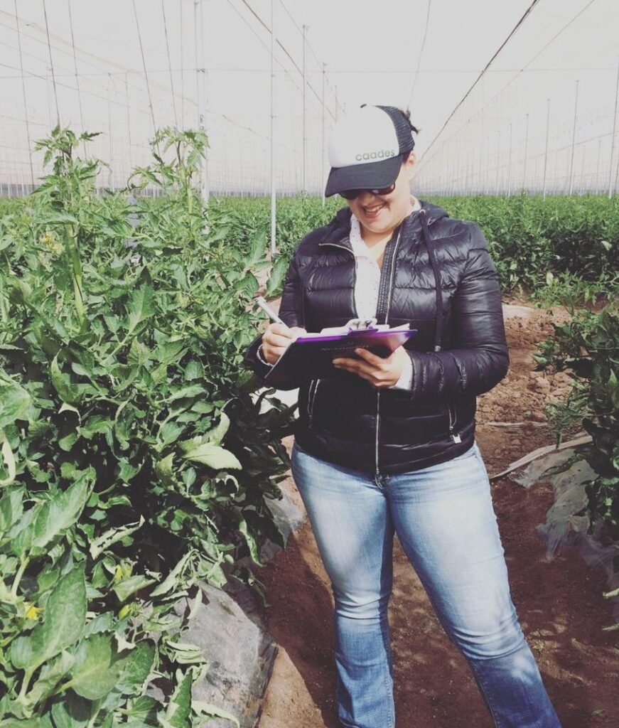 Lourdes Simental durante una evaluación en campo en un invernadero de producción agrícola.